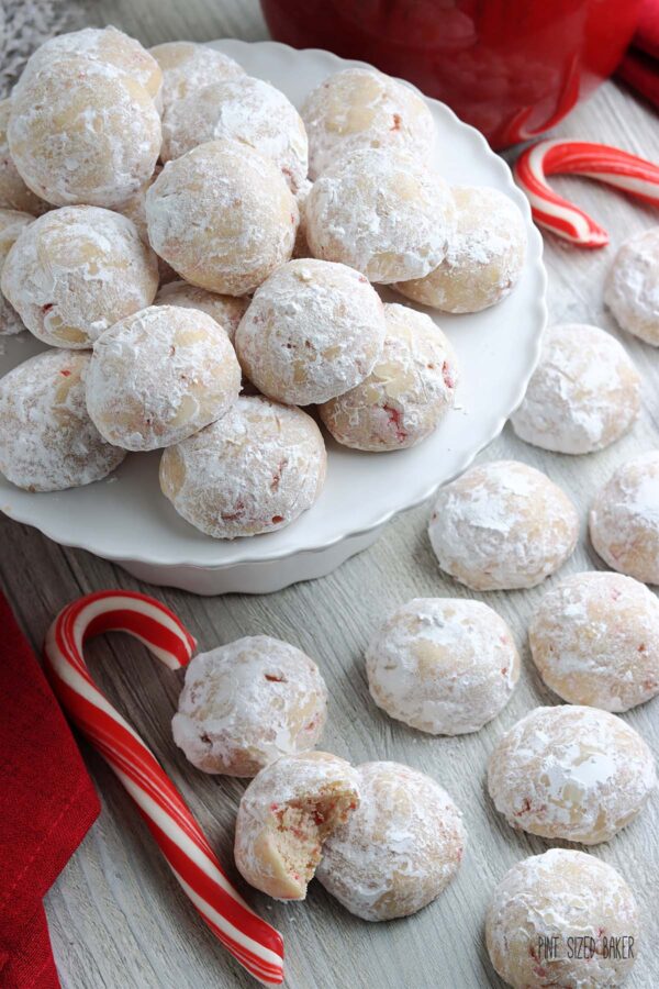 Snowball Cookies on a white platter with candy canes and cookies.