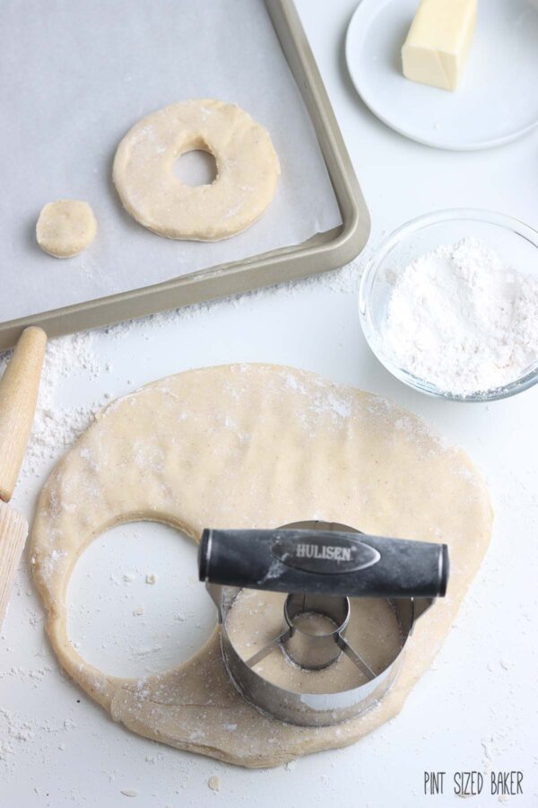 Using a donut cutter to on the dough.