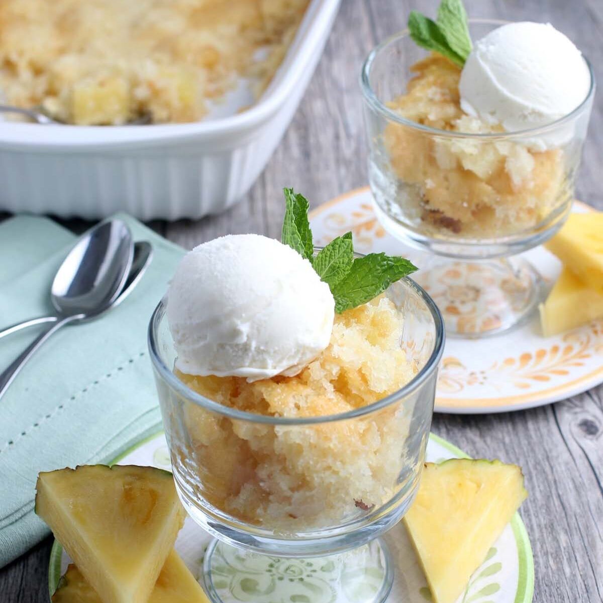 Pineapple Cobbler served up in small glass cups with a scoop of ice cream.